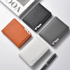 A collection of four slim faux leather business card wallets in shades of orange, gray, and white, displayed on a white surfa