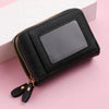 Black floral letter print mini wallet with a double zipper lying on a pink surface.