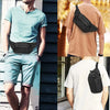A man wearing a light blue shirt and shorts with a black adjustable waist bag and belt.