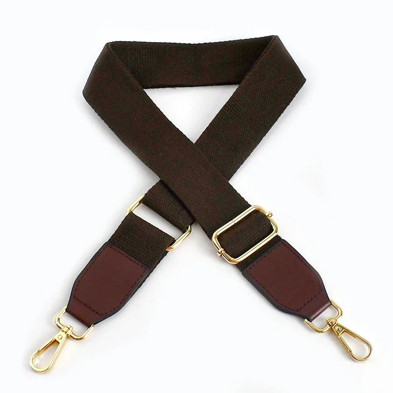 A dark brown canvas cotton bag strap with gold-colored metal hooks, shown in an 'X' shape.