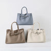 A set of three genuine leather women's shoulder tote bags in gray, beige, and cream.