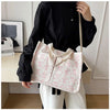 A woman holds a pink canvas tote bag with a white strawberry pattern against a light background.