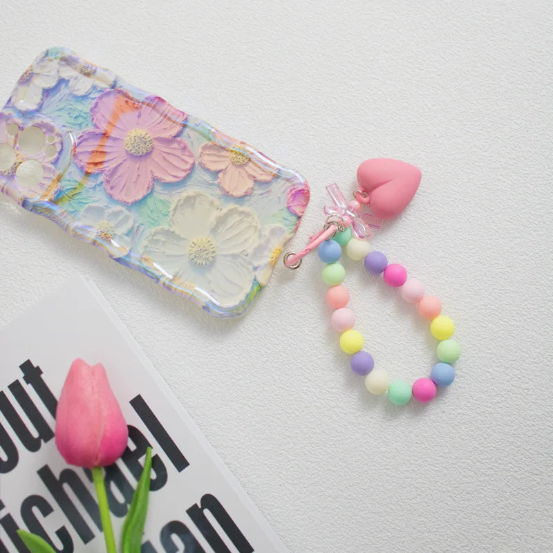 A colorful bead keychain featuring pink and yellow hearts on a string with an O-ring clip.