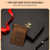 Une boîte cadeau noire et une boîte cadeau orange sont affichées à côté d'un porte-cartes en cuir marron et d'un stylo noir.