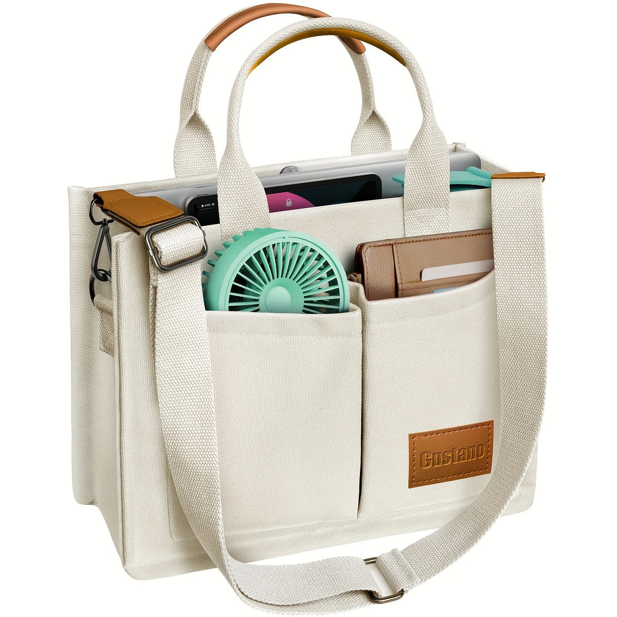A beige canvas tote handbag with light brown leather accents and a green fan inside.