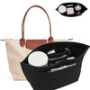 A black felt organizer insert is shown inside a light beige handbag, with cosmetic items visible on top.