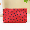 A red cosmetic bag with a leopard print pattern and a zipper, lying on a white surface.