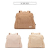 A tan corduroy diaper backpack shown from the back, featuring a flap closure and a small pocket.