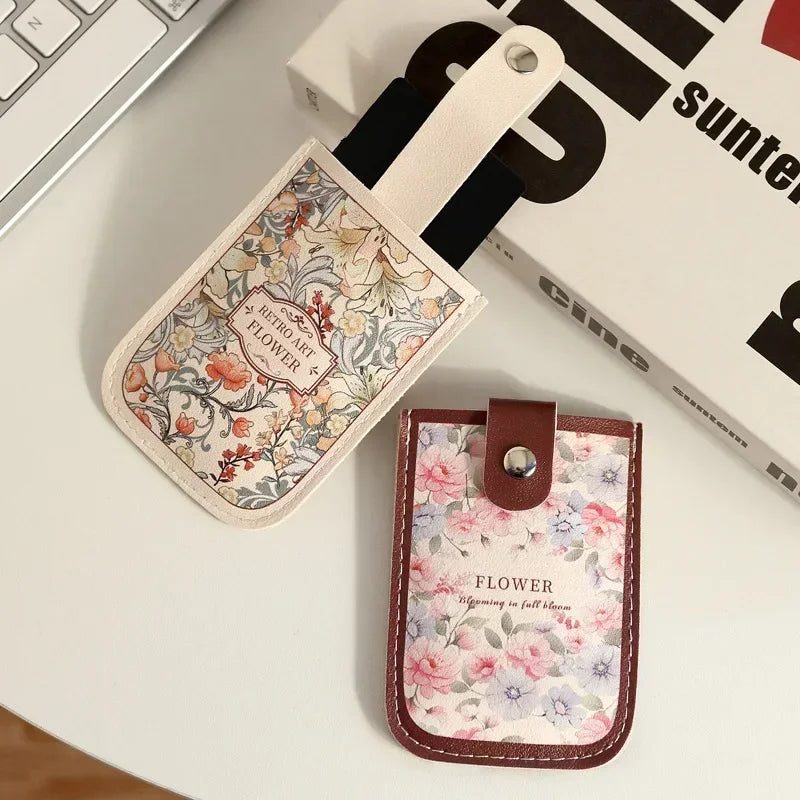 A floral patterned PU card wallet with a leather strap is shown on a white surface.