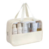 Große, transparente Kosmetik- und Badezusatztasche mit cremefarbener Außenseite und weißen Griffen.