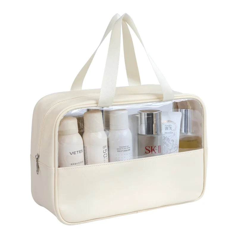 Große, transparente Kosmetik- und Badezusatztasche mit cremefarbener Außenseite und weißen Griffen.