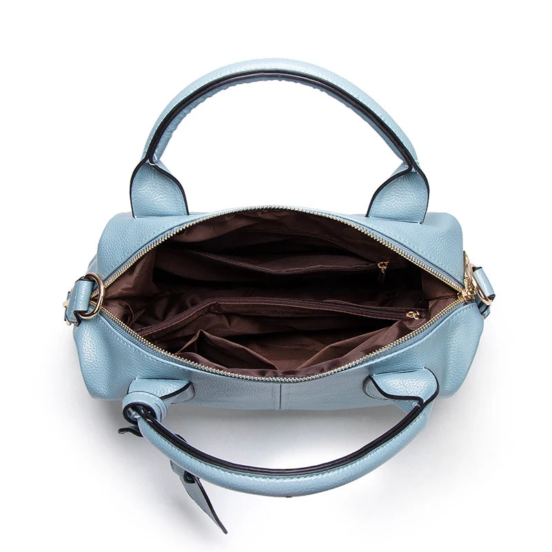 A light blue faux leather Boston handbag with a brown lining and gold hardware.