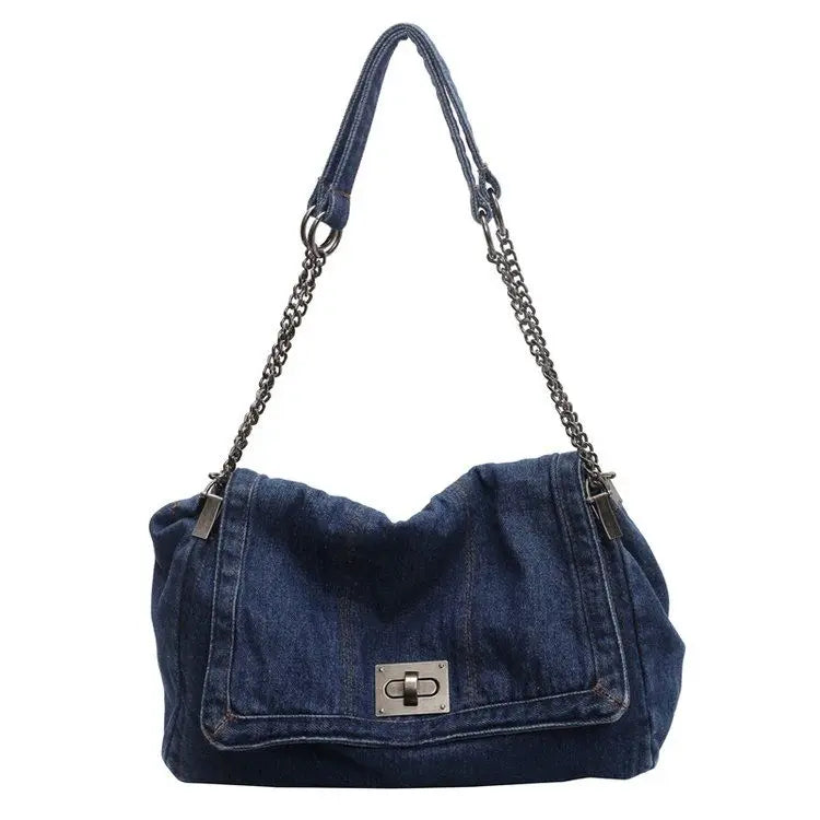 A dark indigo denim tote bag with a chain strap.