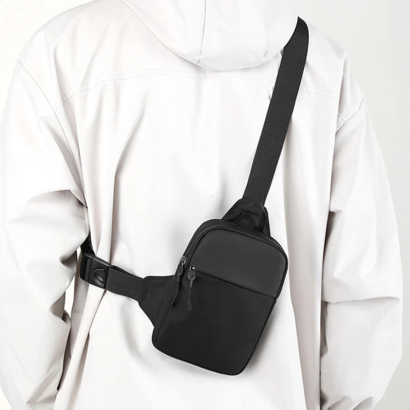 Bolso cruz impermeable negro de pecho usado sobre el torso de una persona.