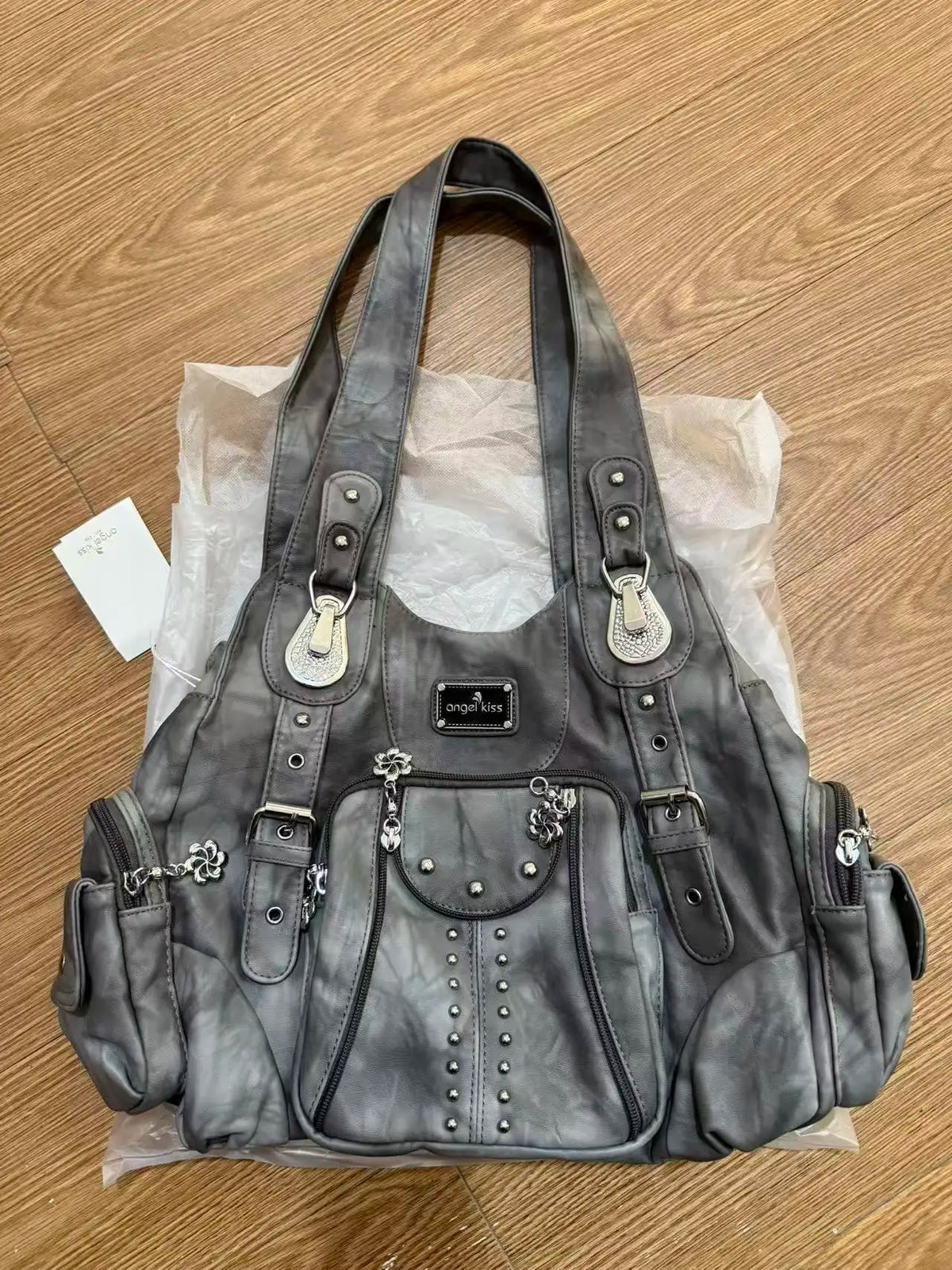 A dark gray vintage PU leather hobo shoulder bag with a drawstring closure and silver hardware, packaged in clear plastic.