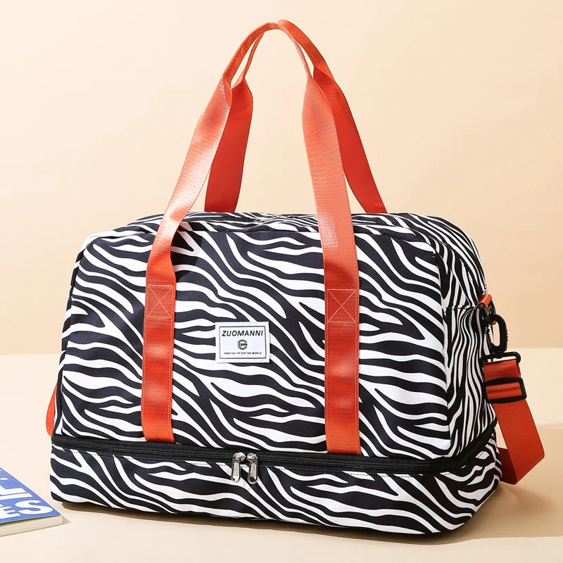 An orange nylon travel duffle bag with a black and white zebra stripe pattern.