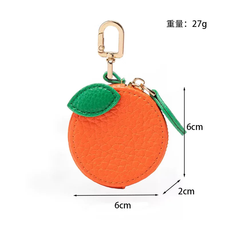 Orange fruit-shaped PU leather coin purse keychain with a green leaf detail and gold-colored hardware