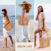 A woman models a woven mesh beach tote bag with woven shoulder straps on a sandy beach.