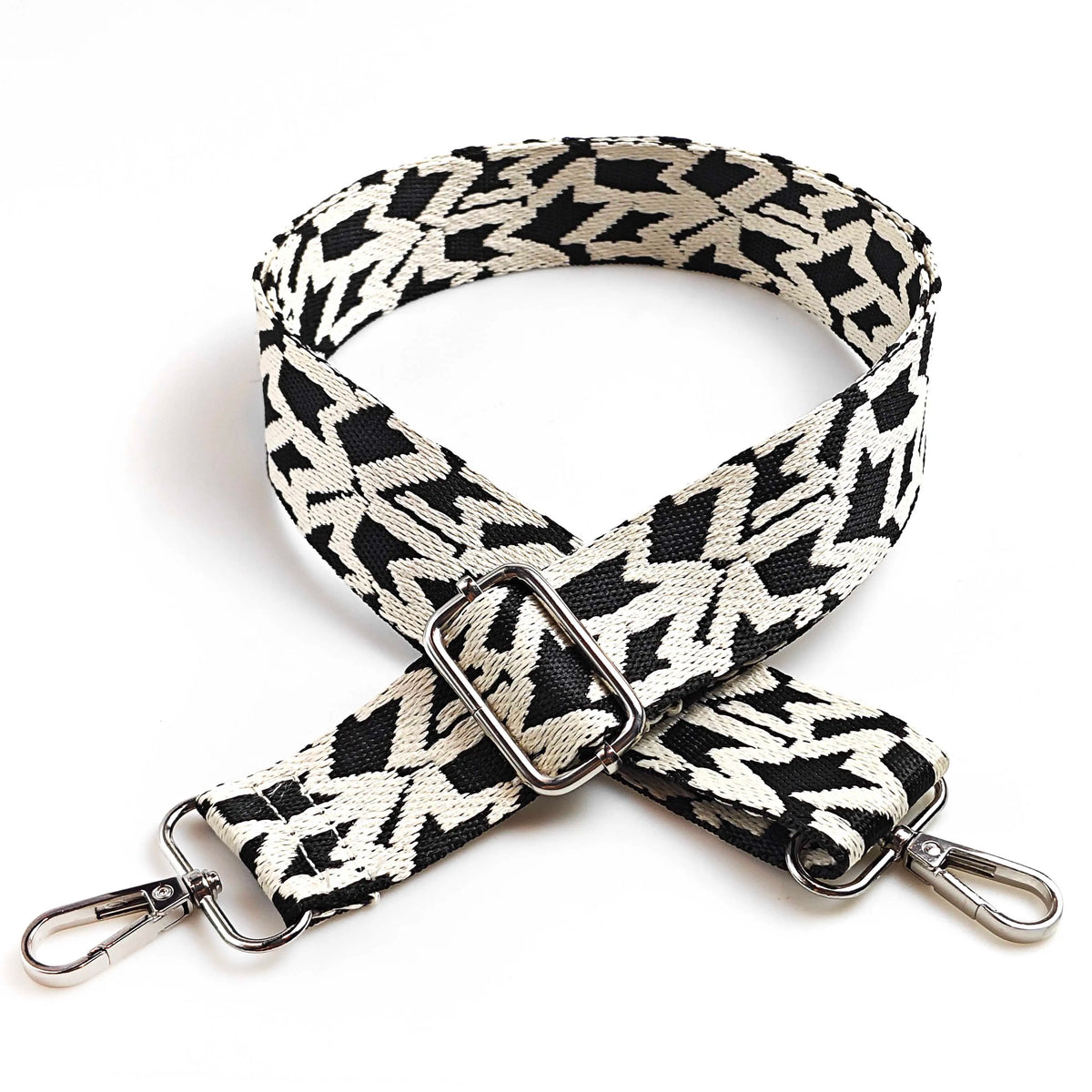 A black and white patterned jacquard strap for an adjustable wide crossbody bag.