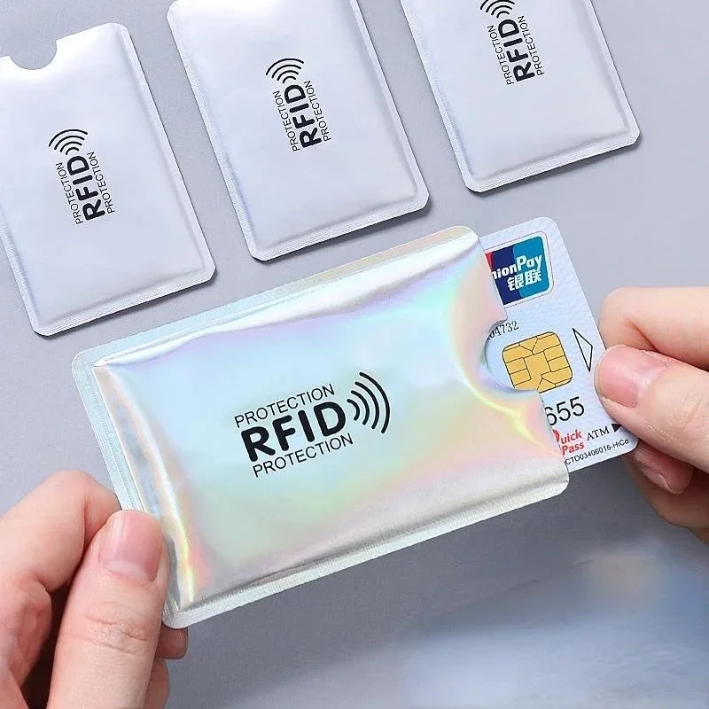 Una mano sostiene una funda bloqueadora de RFID, mostrando una tarjeta de pago y varias fundas en blanco.