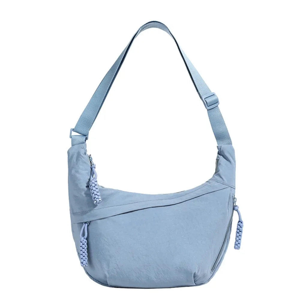 Light blue canvas crossbody bag with adjustable straps and drawstring closure