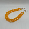 A flexible yellow acrylic chain bracelet with a clasp, displayed against a white background.