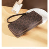 A brown patterned PU leather zippered wallet is shown next to a glass bottle.