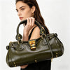 A woman holds a dark olive green vegan leather tote bag with gold hardware.