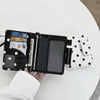 A black polka dot passport holder displaying multiple card slots and a clear ID card.