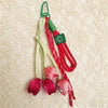 A set of red and green tassel bag charms featuring tulip flower shapes on a light background.