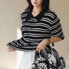 A woman models a black and white striped top and white pants while holding a spacious black leopard print PU leather tote bag
