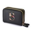 Black faux leather mini wallet with a gold zipper and a floral letter print