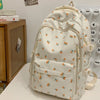 Mochila de color crema con estampado floral de hojas naranjas y verdes, sobre fondo blanco.