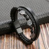A black leather bracelet featuring multiple strands and tiger eye beads resting on a dark surface.