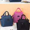 Three insulated canvas tote bags in navy blue, pink, and black are displayed on a white surface.
