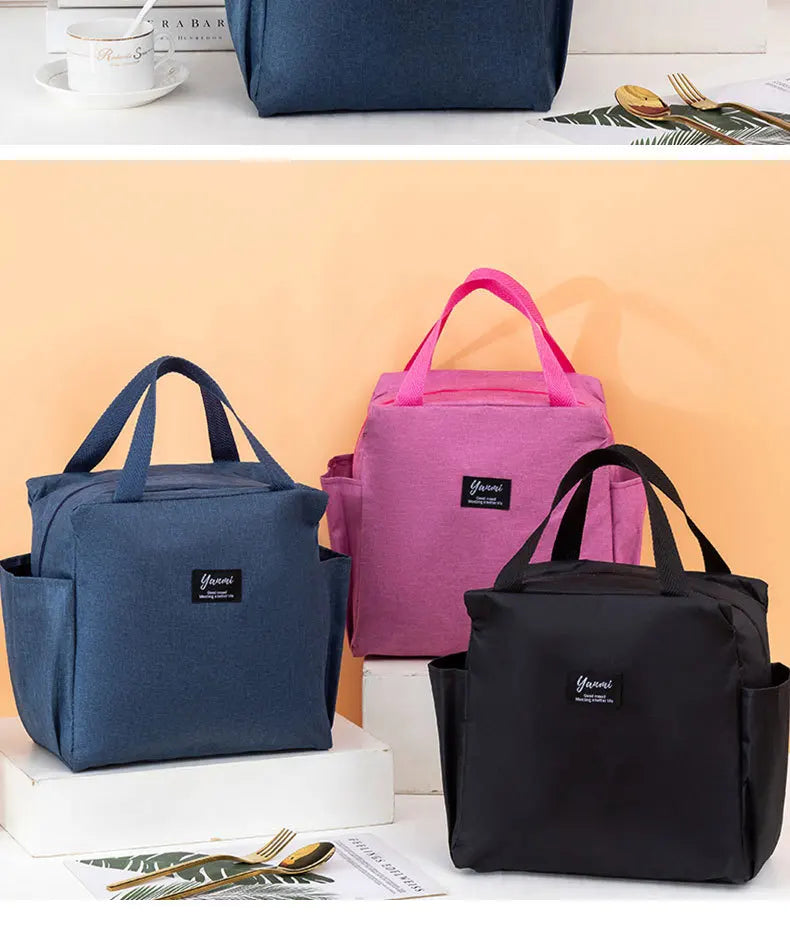 Three insulated canvas tote bags in navy blue, pink, and black are displayed on a white surface.