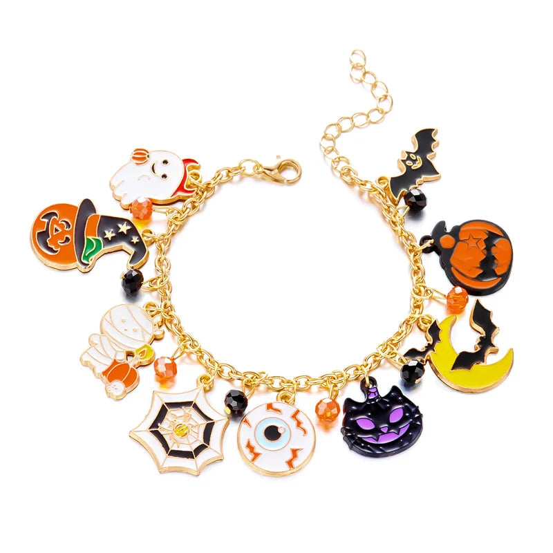 A gold charm bracelet featuring Halloween themed charms including a ghost, pumpkin, and witch silhouette.
