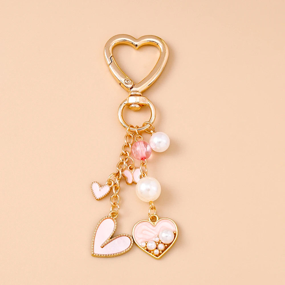 Gold-toned pearl bow heart keychain with a heart-shaped clasp and dangling pearls