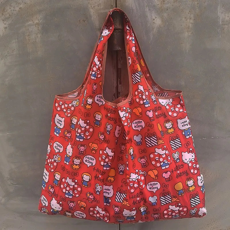 A bright orange reusable shopping bag with a pattern of cute characters and designs hanging against a gray background.