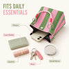 A pink and green striped knit bucket tote bag is shown open, revealing various daily essentials like a phone, card wallet, li