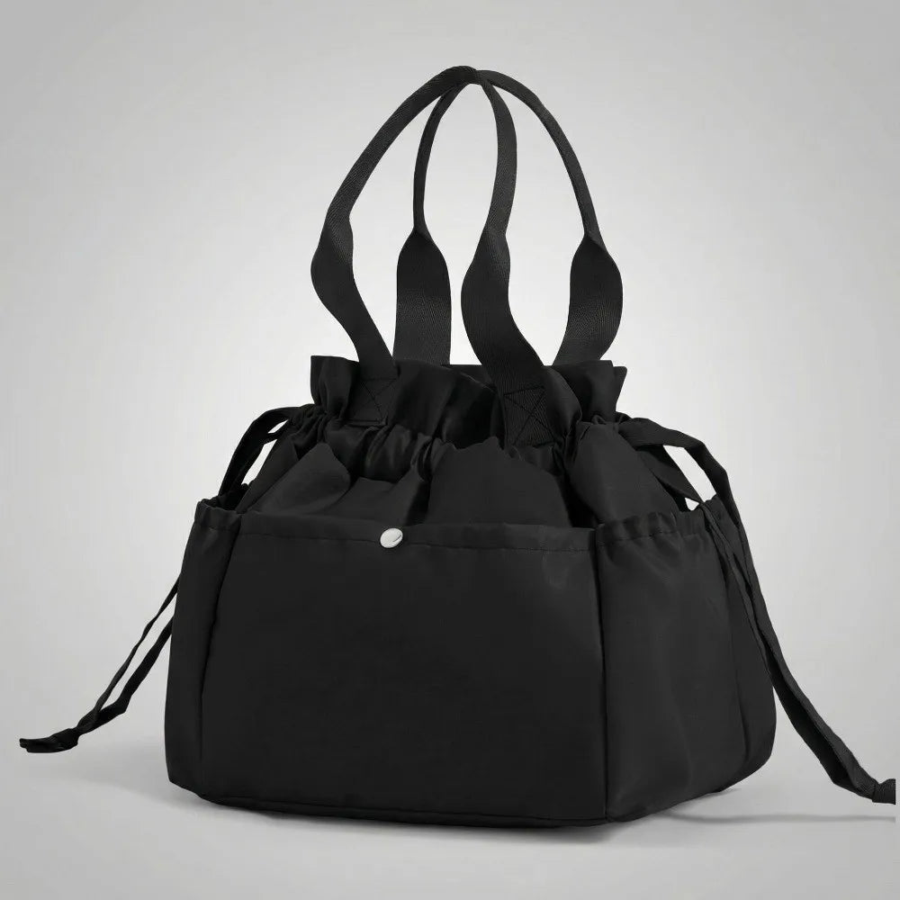 A black insulated drawstring lunch bag with multiple pockets is shown against a light gray background.