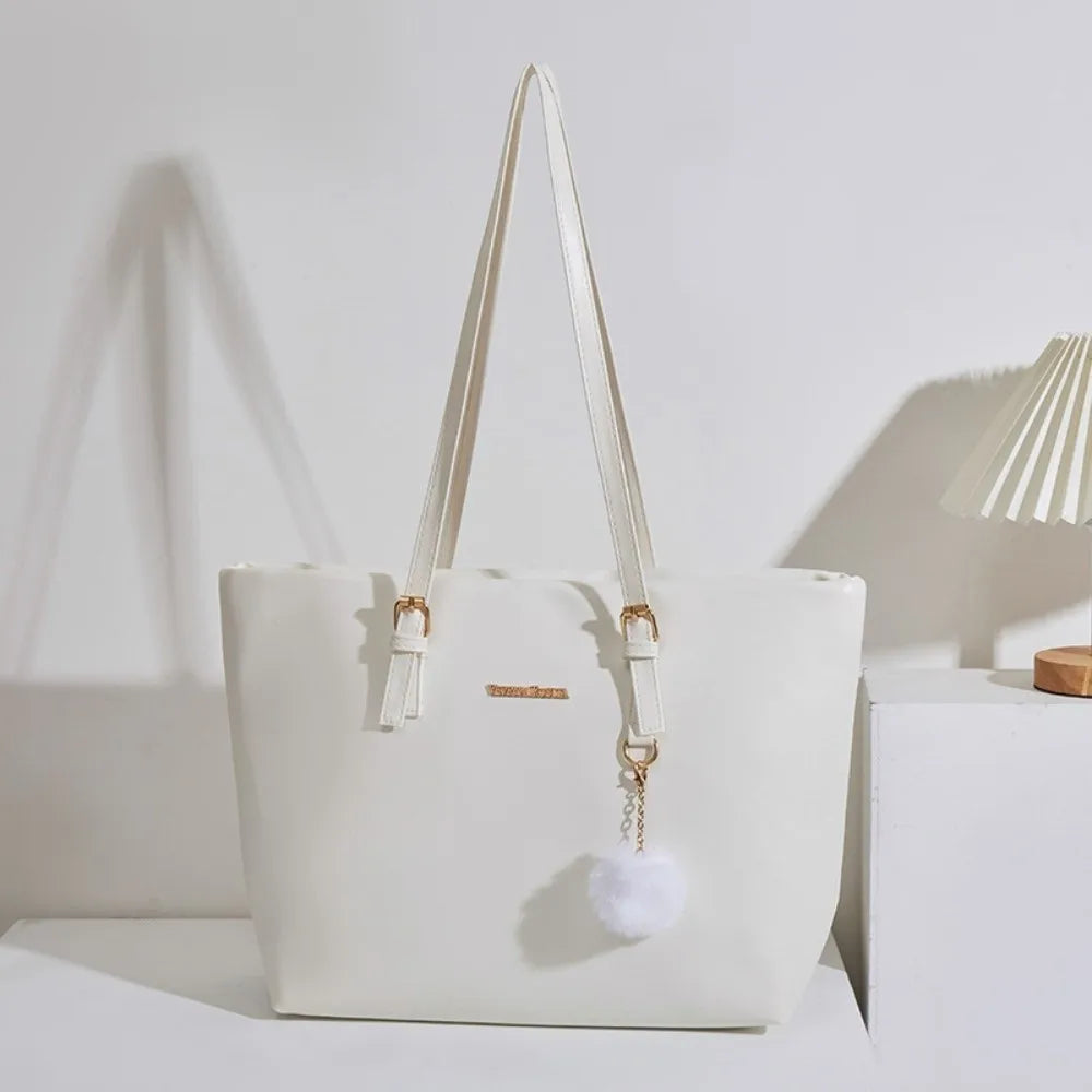 Bolso de hombro de cuero PU color crema con tirantes beige claro y un charm de pompom esponjoso.