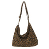 A brown leopard print canvas shoulder bag with an adjustable strap.