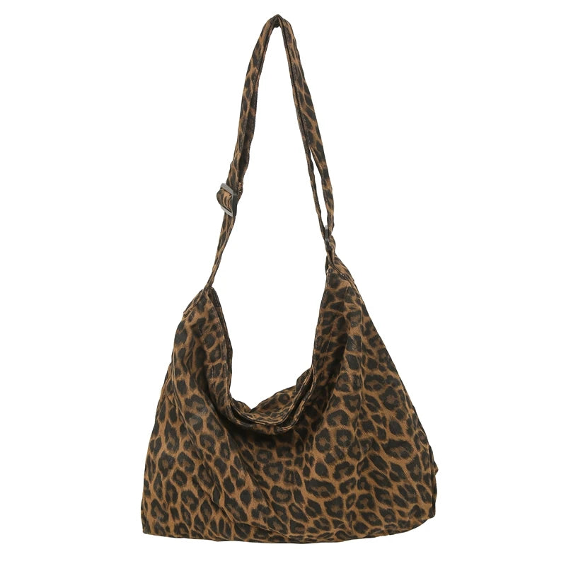 A brown leopard print canvas shoulder bag with an adjustable strap.
