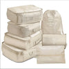 A set of seven beige folding travel organizer bags including storage pouches and a large drawstring bag.