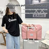 A woman is holding a pink canvas travel storage bag next to a silver suitcase.