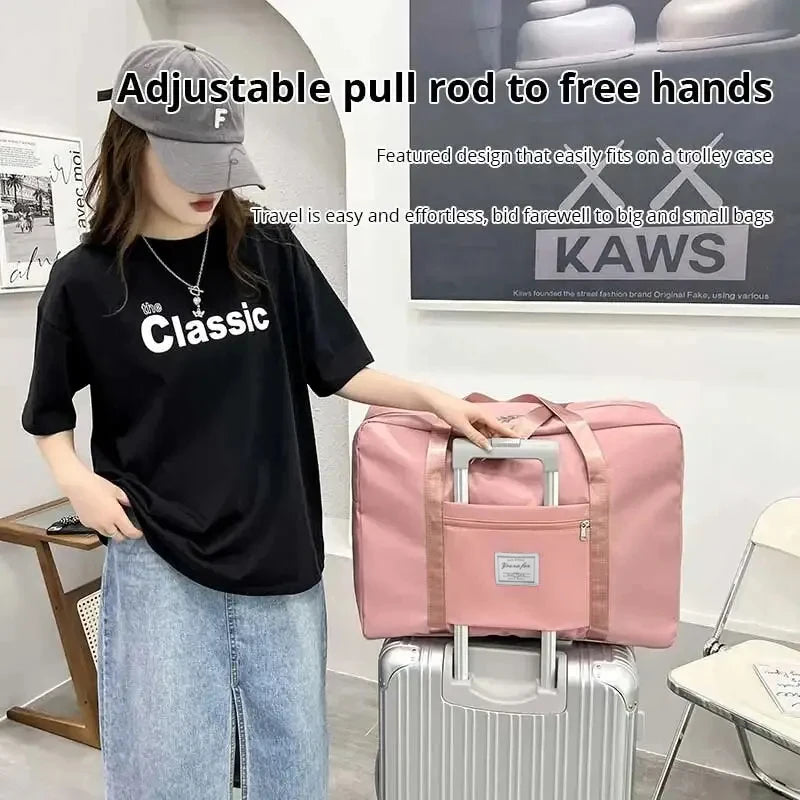 A woman is holding a pink canvas travel storage bag next to a silver suitcase.