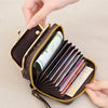 A close-up of a black leather accordion card holder wallet with gold accents and a repeating pattern, shown being held by a h