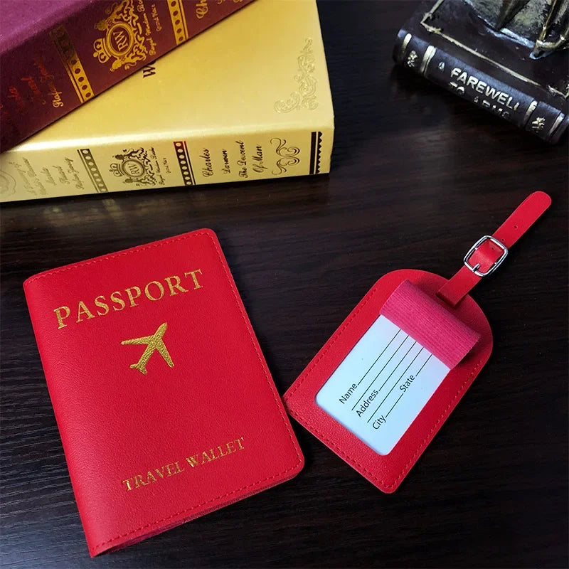 A red PU leather passport wallet and a pink passport holder are displayed on a dark wooden surface next to old books.