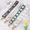 A collection of adjustable nylon bag straps in various patterns and colors laid out on a marble surface.